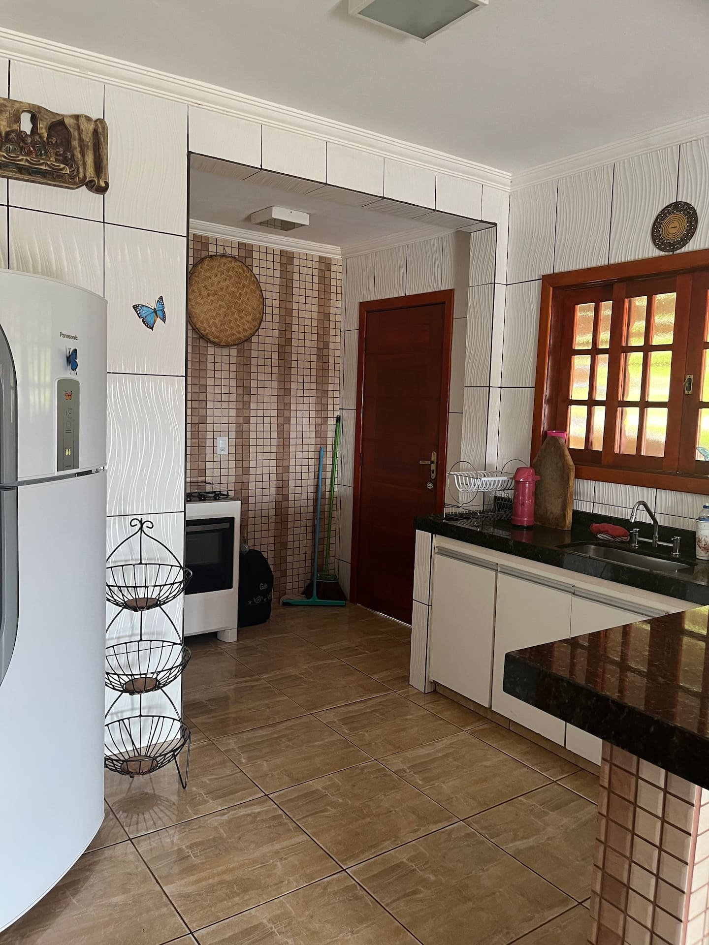 Cozinha da casa grande, com bancada, armários e eletrodomésticos.