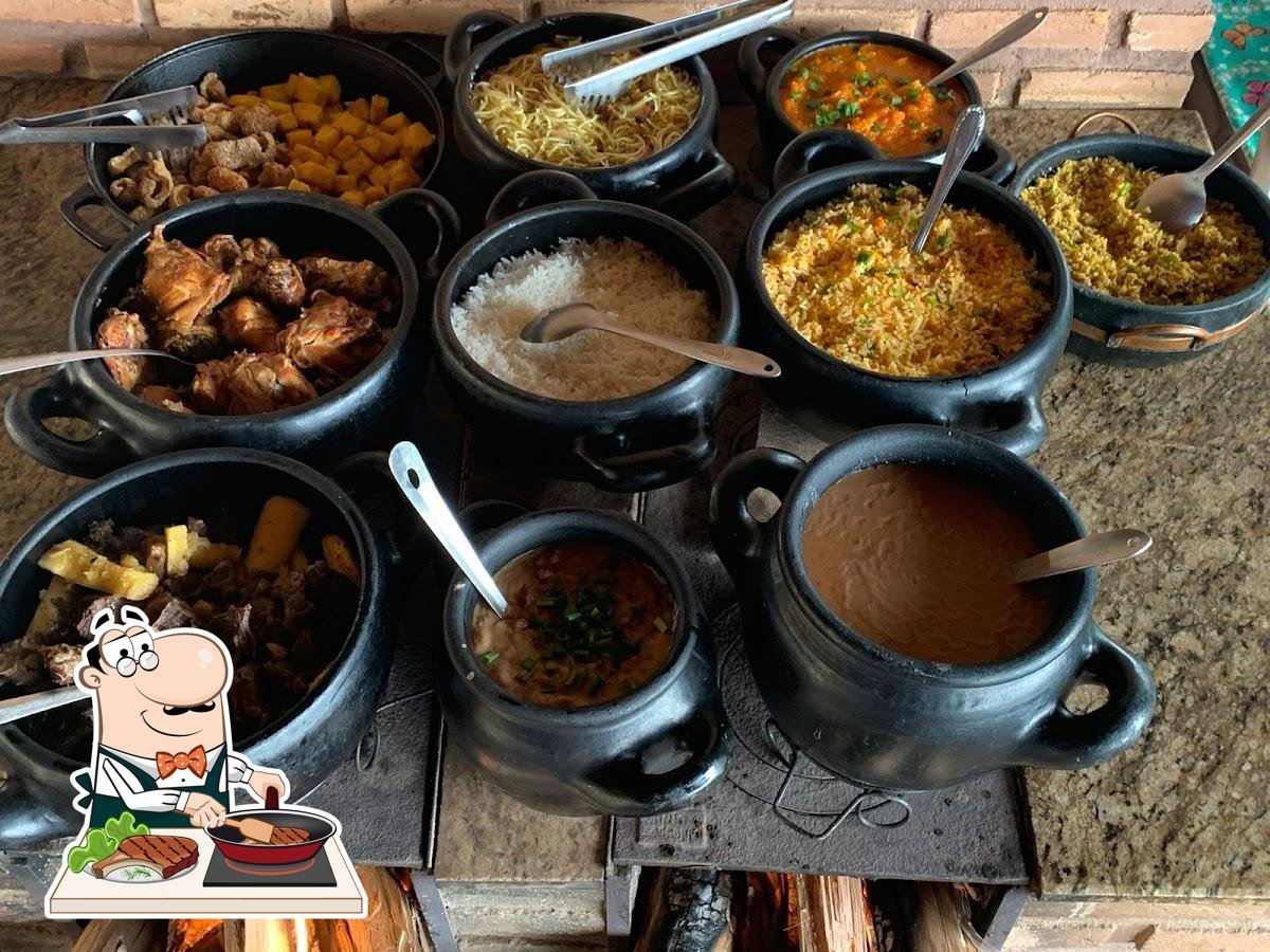 Buffet de comida mineira em panelas de barro no restaurante.