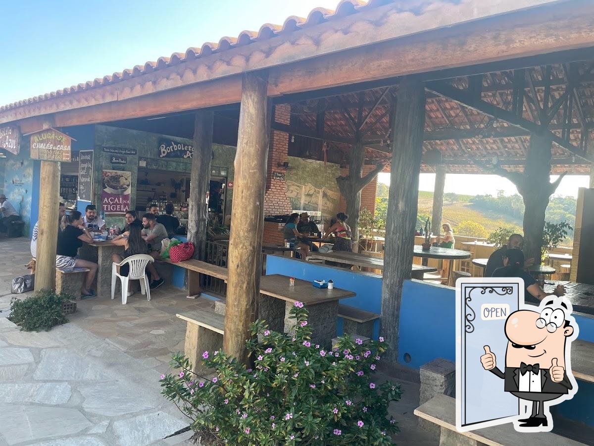 Fachada aberta do Bar e Restaurante Borboleta Azul, com pilares de madeira e balcão azul.